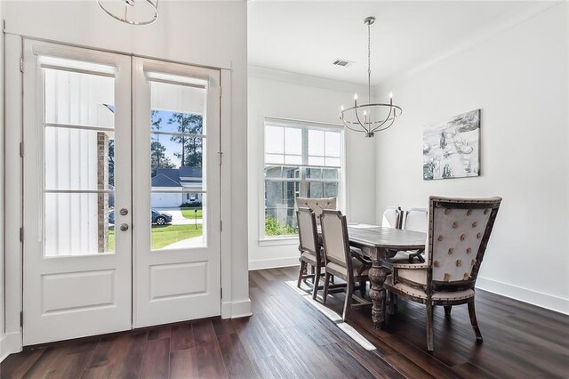 dining room featuring crown molding, dark wood-type flooring, french doors, and a chandelier