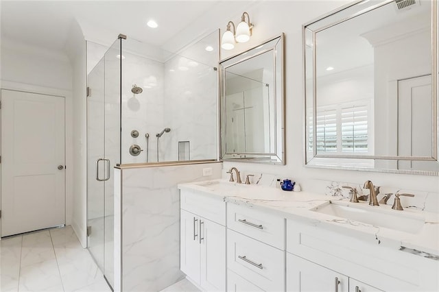 bathroom with a shower with shower door, double vanity, and tile patterned floors