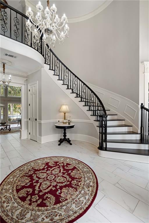 interior space featuring crown molding, a high ceiling, and an inviting chandelier