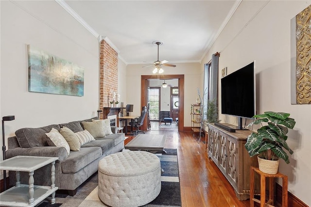 living room with crown molding, dark wood-type flooring, and ceiling fan