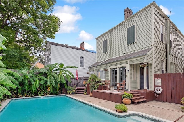 back of property with a pool side deck and a patio