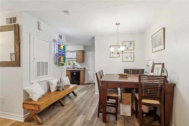 dining room with hardwood / wood-style floors and a chandelier