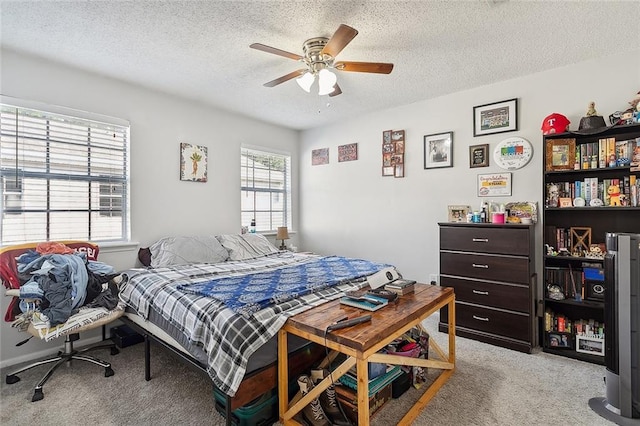 bedroom with ceiling fan, a textured ceiling, and light colored carpet