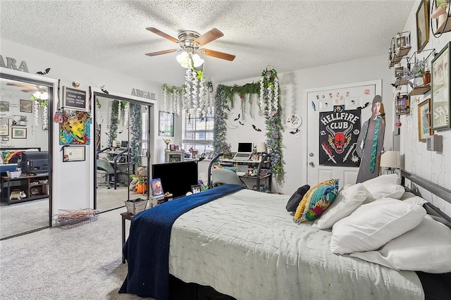 carpeted bedroom featuring ceiling fan and a textured ceiling