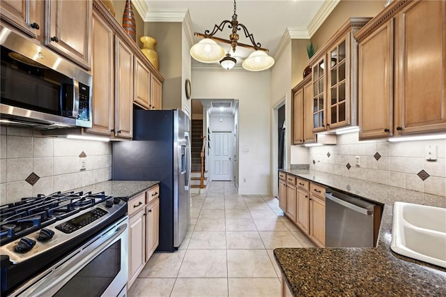 kitchen featuring decorative backsplash, appliances with stainless steel finishes, and dark stone countertops