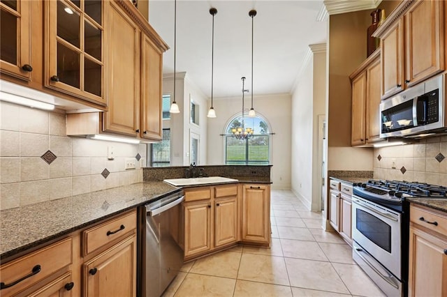 kitchen featuring appliances with stainless steel finishes, ornamental molding, dark stone counters, light tile patterned floors, and decorative backsplash