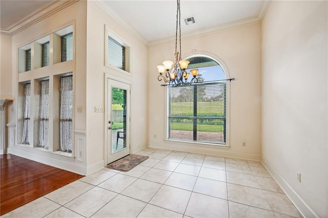 doorway featuring light hardwood / wood-style flooring, ornamental molding, and a notable chandelier