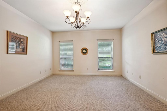 empty room with carpet flooring and an inviting chandelier