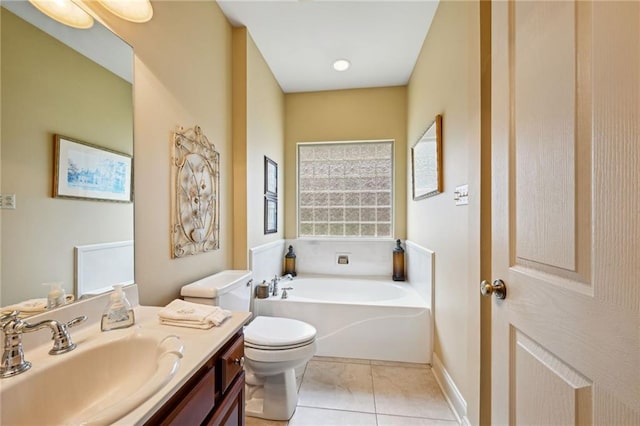 bathroom featuring vanity, a washtub, tile patterned flooring, and toilet