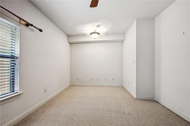 carpeted spare room with ceiling fan and plenty of natural light