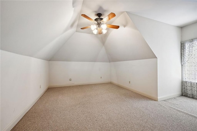 additional living space featuring ceiling fan, vaulted ceiling, and light colored carpet