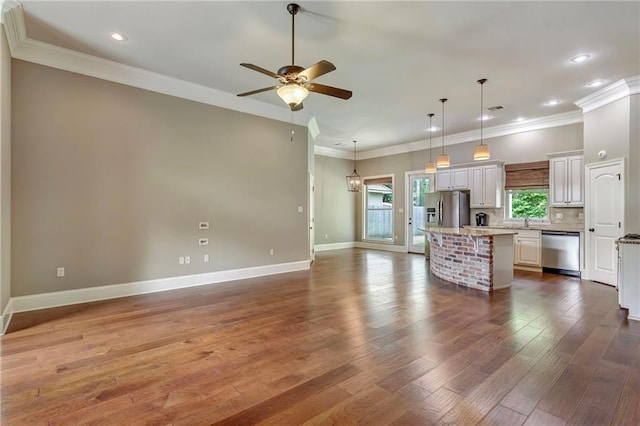 kitchen with a center island, a ceiling fan, open floor plan, appliances with stainless steel finishes, and dark wood-style flooring