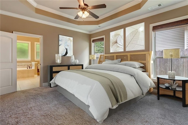 tiled bedroom featuring ceiling fan, ensuite bathroom, ornamental molding, and a tray ceiling