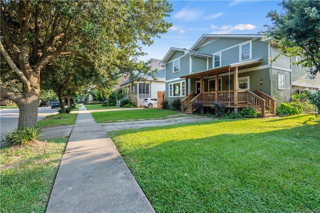 back of property with covered porch and a yard