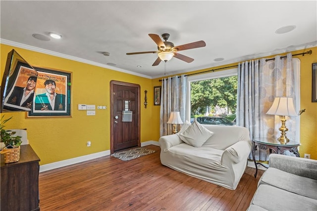 living room with hardwood / wood-style floors, crown molding, and ceiling fan