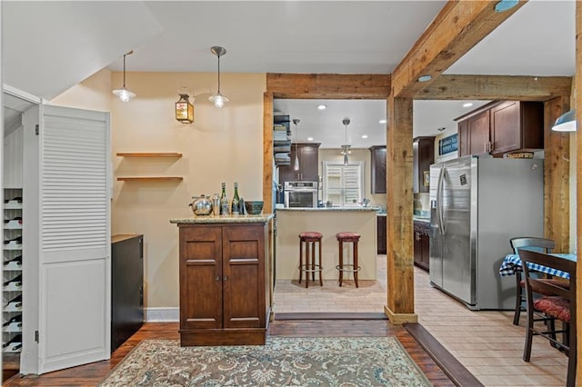 kitchen with stainless steel appliances, dark hardwood / wood-style flooring, pendant lighting, beam ceiling, and kitchen peninsula