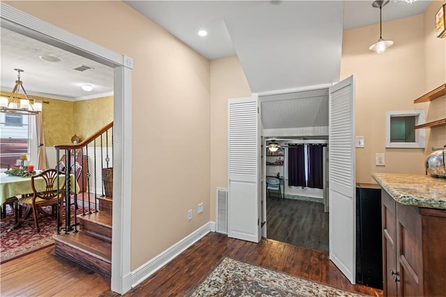 interior space featuring a notable chandelier, dark wood-type flooring, and hanging light fixtures