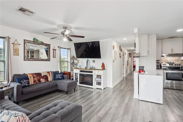 living room featuring light wood-type flooring and ceiling fan