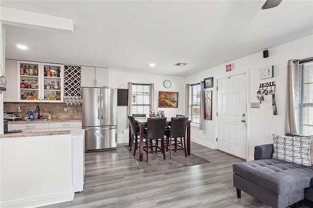 dining area with ceiling fan, sink, and light hardwood / wood-style floors