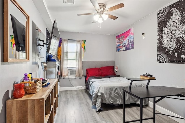 bedroom with ceiling fan, light hardwood / wood-style flooring, and cooling unit