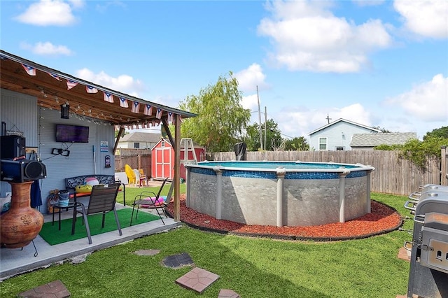 view of pool featuring a lawn and a storage unit