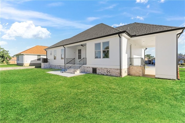 rear view of property featuring a yard and central air condition unit