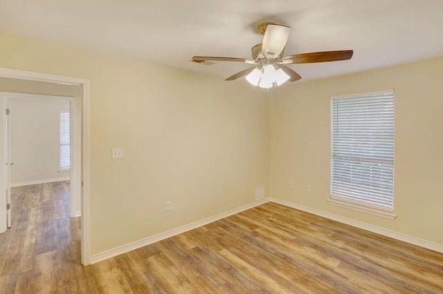 spare room with ceiling fan and light wood-type flooring