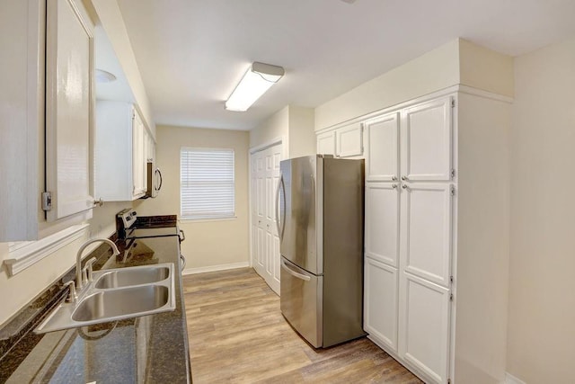 kitchen featuring appliances with stainless steel finishes, sink, light hardwood / wood-style flooring, and white cabinetry