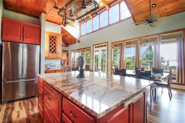 kitchen featuring refrigerator, a kitchen island, wood ceiling, and hardwood / wood-style flooring