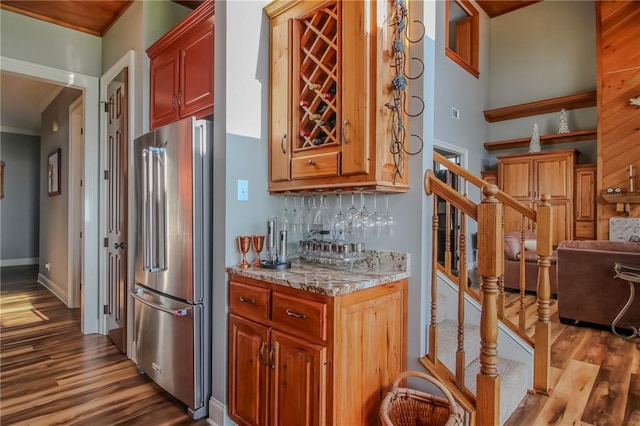 kitchen with tasteful backsplash, light hardwood / wood-style flooring, and stainless steel fridge