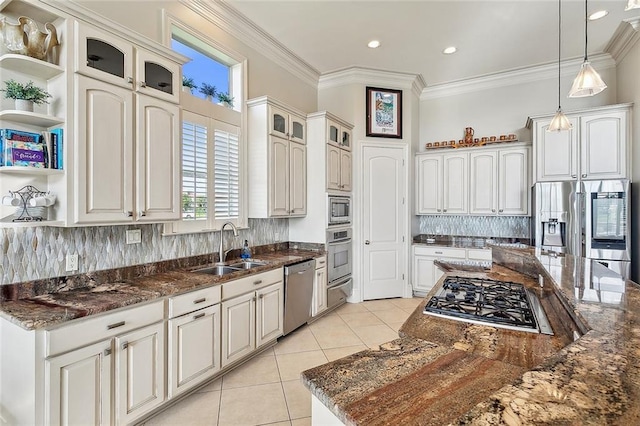 kitchen featuring decorative backsplash, hanging light fixtures, stainless steel appliances, and sink