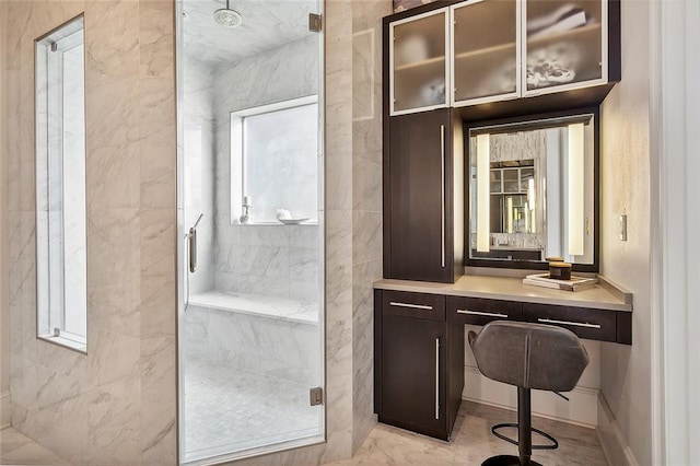 bathroom with tile patterned floors, vanity, and tiled shower