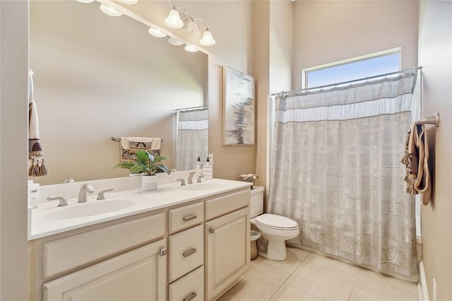 bathroom with dual vanity, toilet, and tile patterned floors