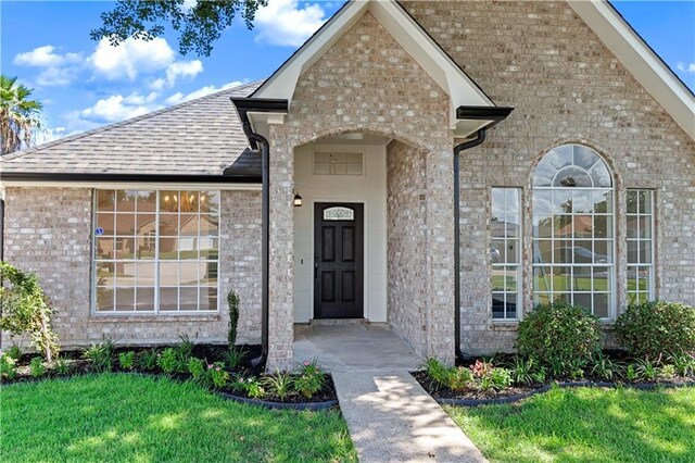 doorway to property with a lawn