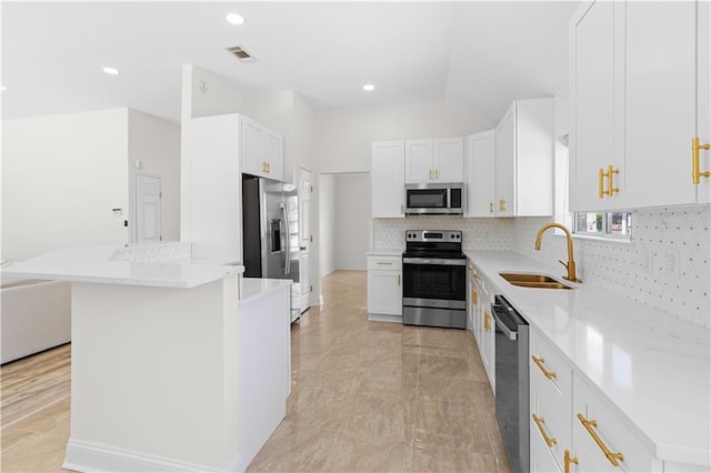 kitchen featuring sink, stainless steel appliances, backsplash, and white cabinetry