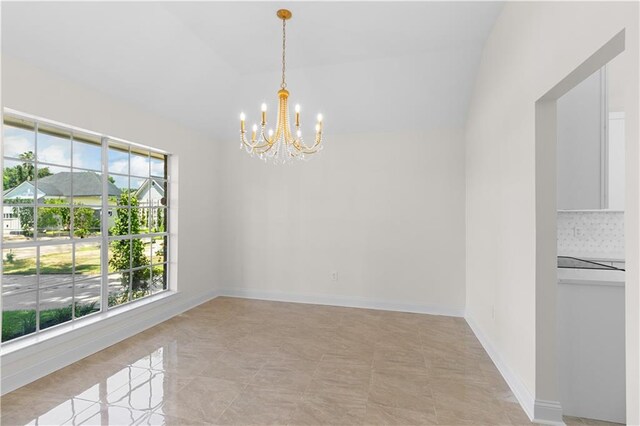 tiled empty room with lofted ceiling, an inviting chandelier, and a healthy amount of sunlight