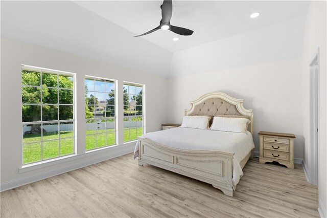 bedroom with ceiling fan, light hardwood / wood-style flooring, lofted ceiling, and multiple windows