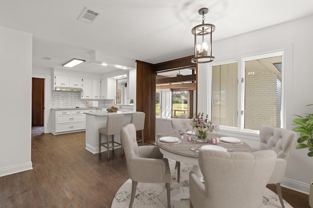 dining room featuring dark hardwood / wood-style flooring and a chandelier