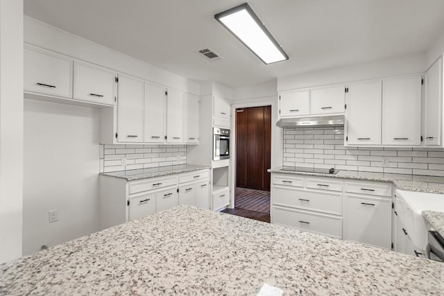 kitchen with black electric stovetop, backsplash, white cabinetry, and dark wood-type flooring