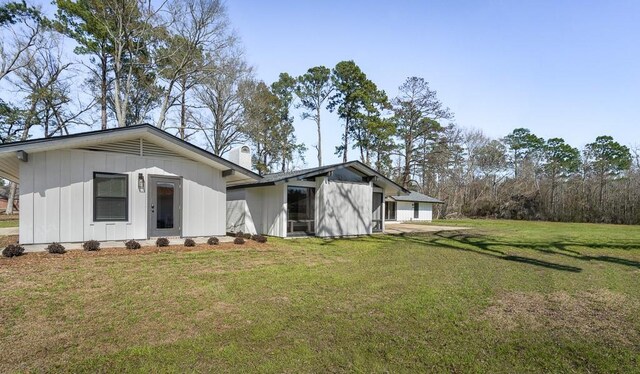 back of house with a yard and a garage