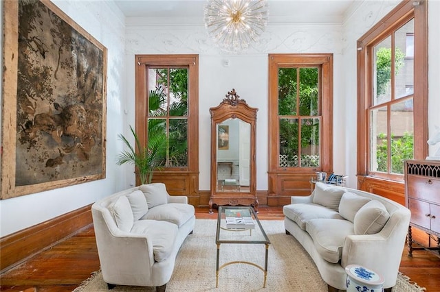 sitting room featuring an inviting chandelier, wood finished floors, and a healthy amount of sunlight