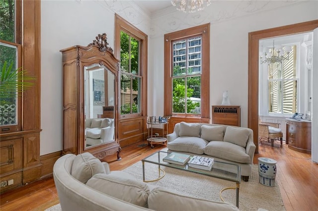 sitting room featuring hardwood / wood-style floors, a chandelier, and crown molding