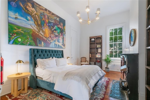 bedroom with a chandelier and wood finished floors