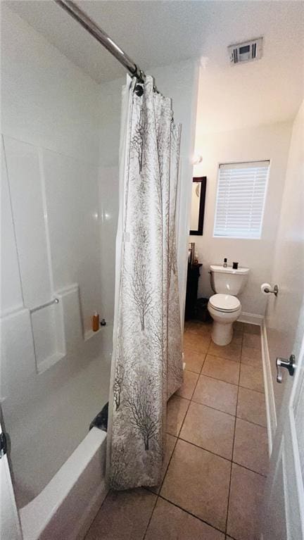 bathroom with toilet, tile patterned floors, and shower / bath combo with shower curtain