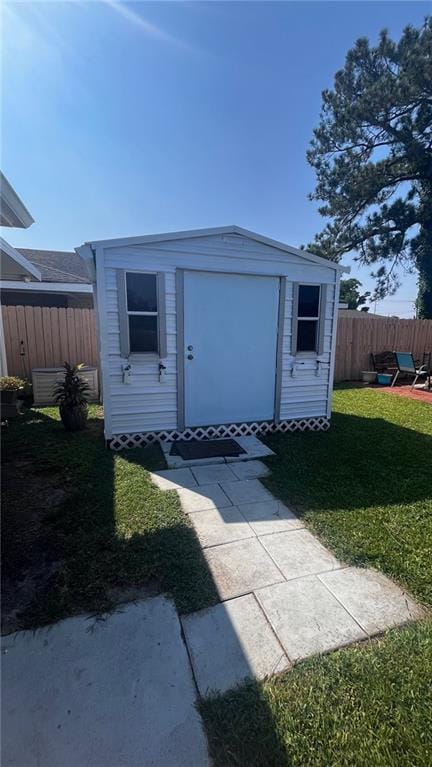 view of front of property featuring a storage shed and a front yard