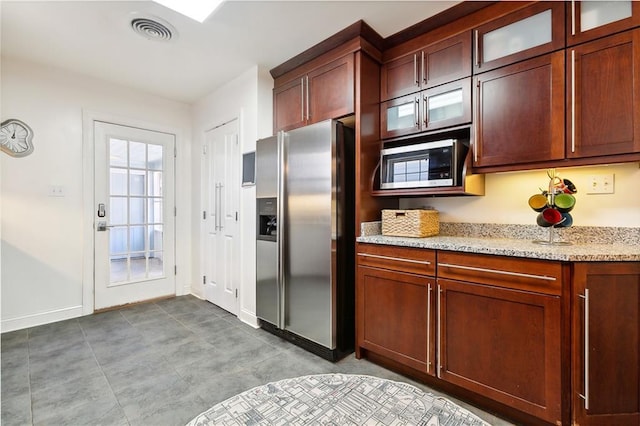 kitchen featuring light stone countertops, a healthy amount of sunlight, and appliances with stainless steel finishes