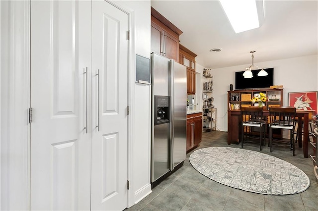 kitchen featuring hanging light fixtures and stainless steel refrigerator with ice dispenser