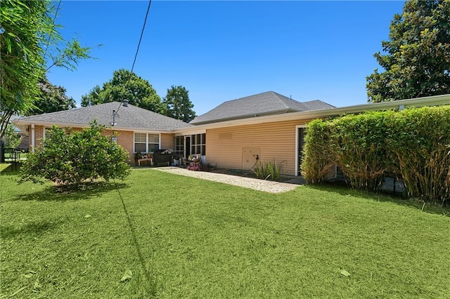 rear view of house featuring a yard and a patio area