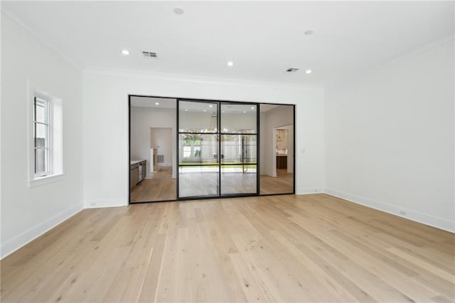 unfurnished room featuring ornamental molding and light hardwood / wood-style flooring