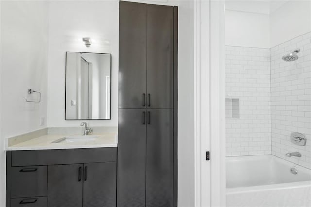 bathroom featuring vanity and tiled shower / bath